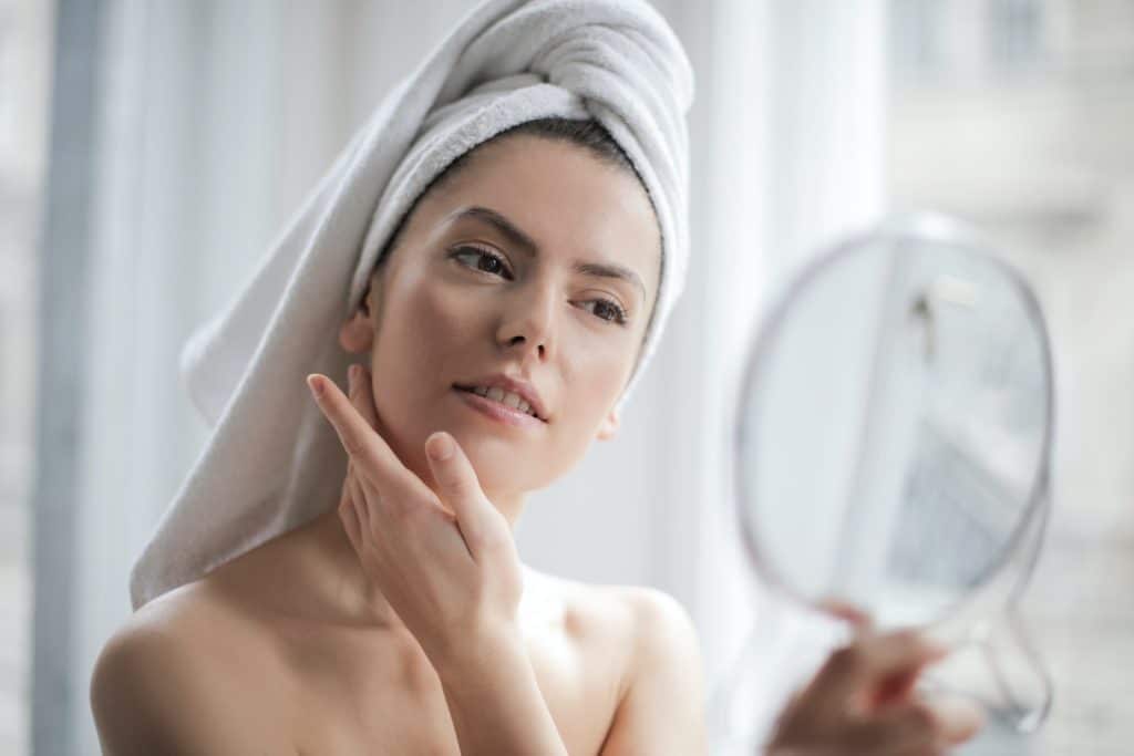 Selective Focus Portrait Photo Of Woman With A Towel On Head Looking In The Mirror