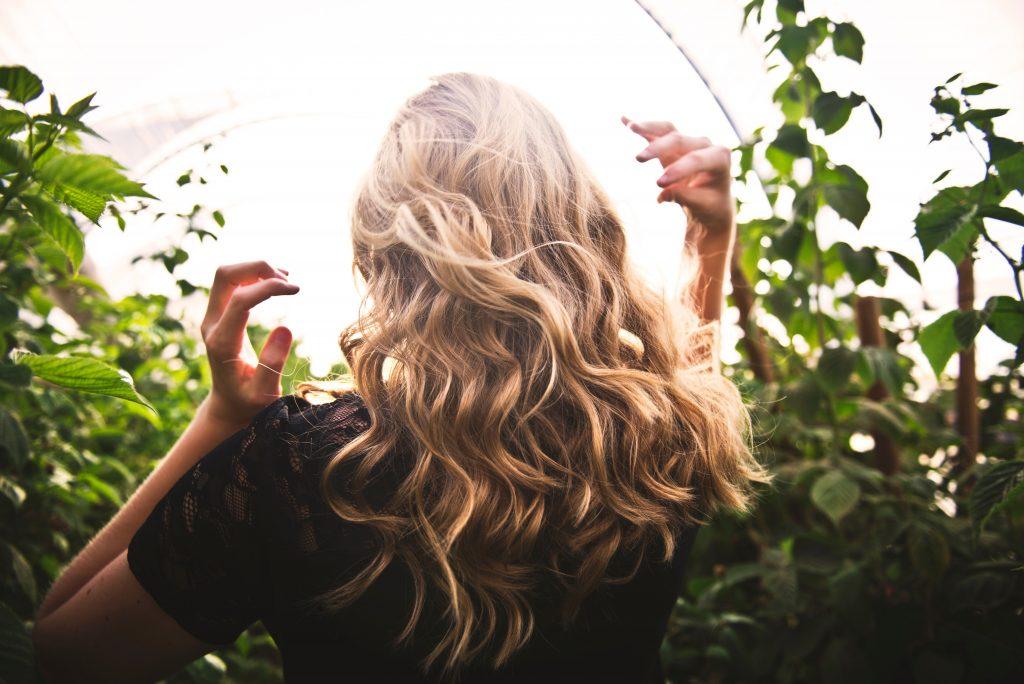 Blonde Female Walking Along Nature And Green Leaves