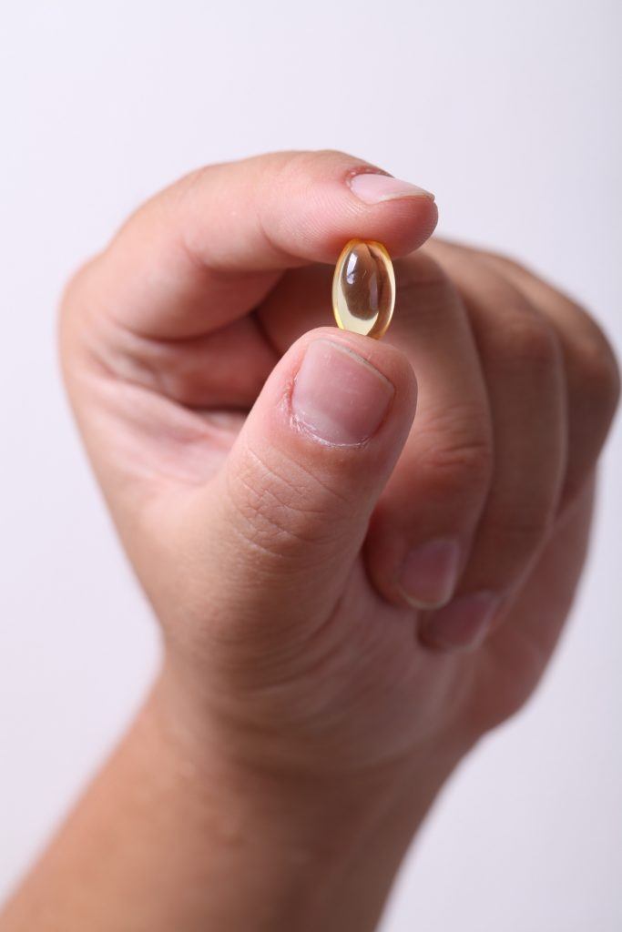 Yellow Clear Gel Pill/Medication/Supplement Being Held In Hand