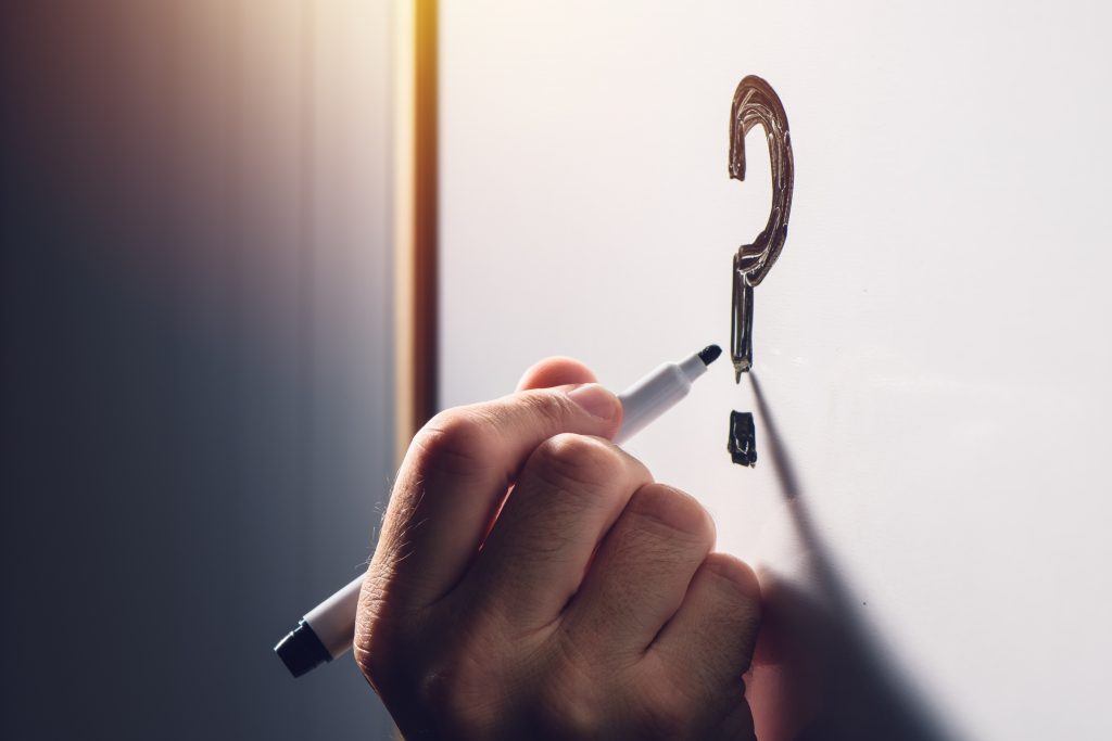 Man Writing Question Mark On Whiteboard