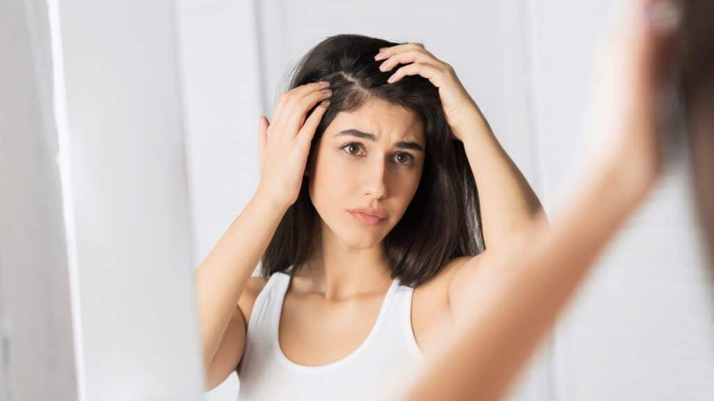 Girl Looking At Hair Flakes In Mirror Standing In Mqkjt5C 1024X576 1 - Manuka Essential Oil